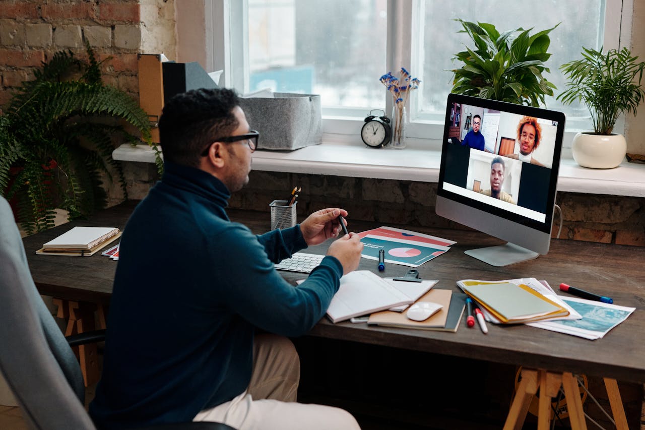 Home Man engaging in an online meeting from home office, showcasing remote work dynamics.